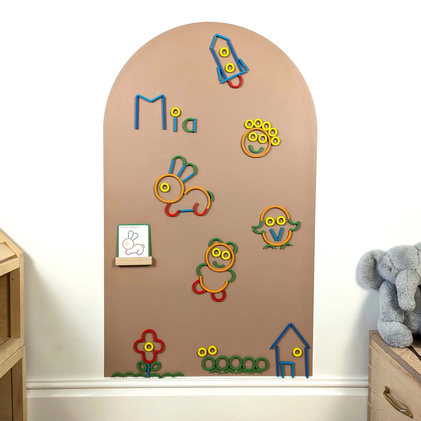 lots of colourful magnetic wooden shapes making different pictures of animals and things on a clay coloured wall decal