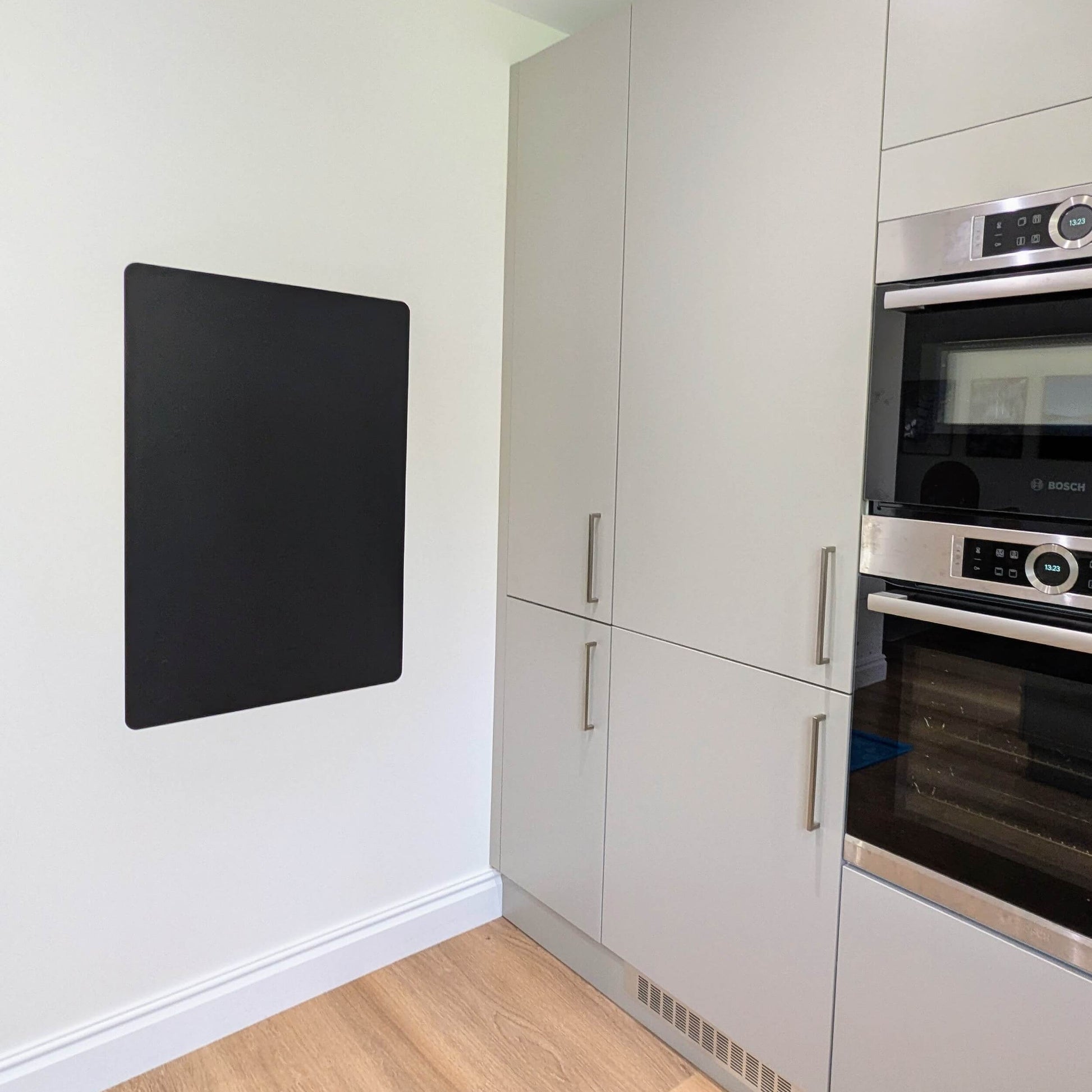 Grey kitchen with blank black rectangular chalkboard on wall