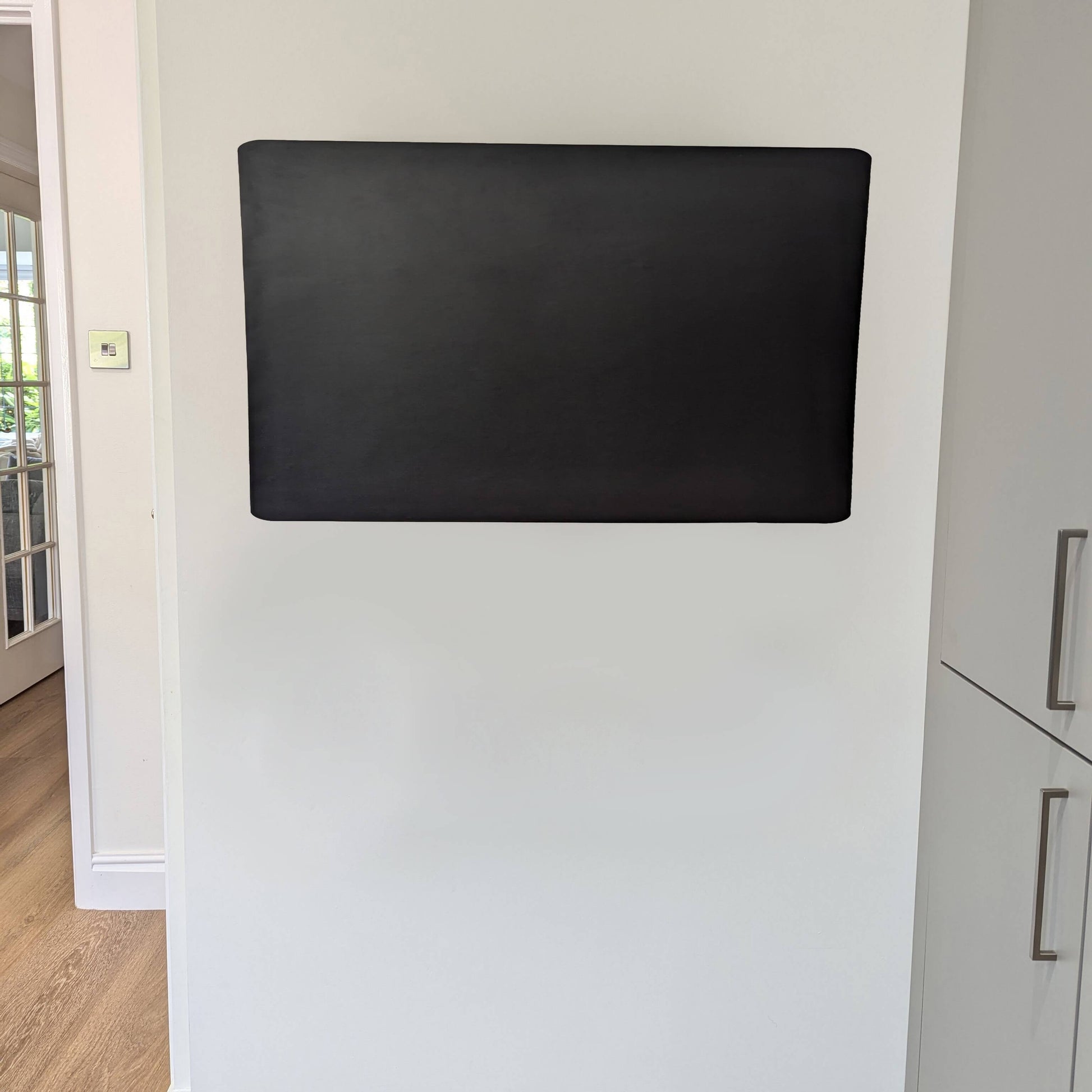 Landscape orientated blank black noticeboard or blackboard on a kitchen wall at home